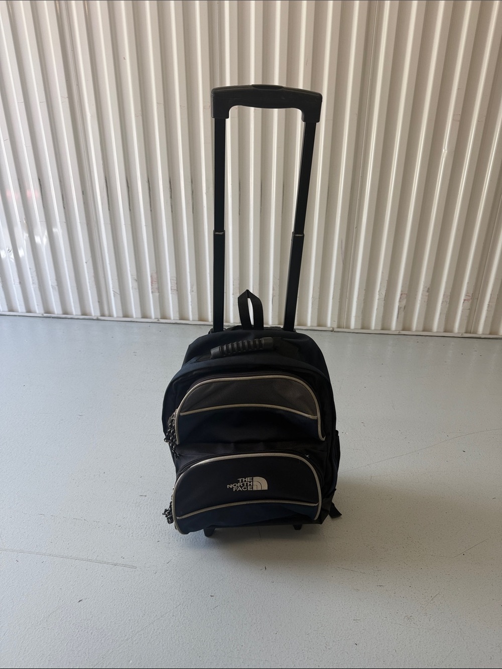 The North Face Black Rolling Travel Backpack with Silver Piping